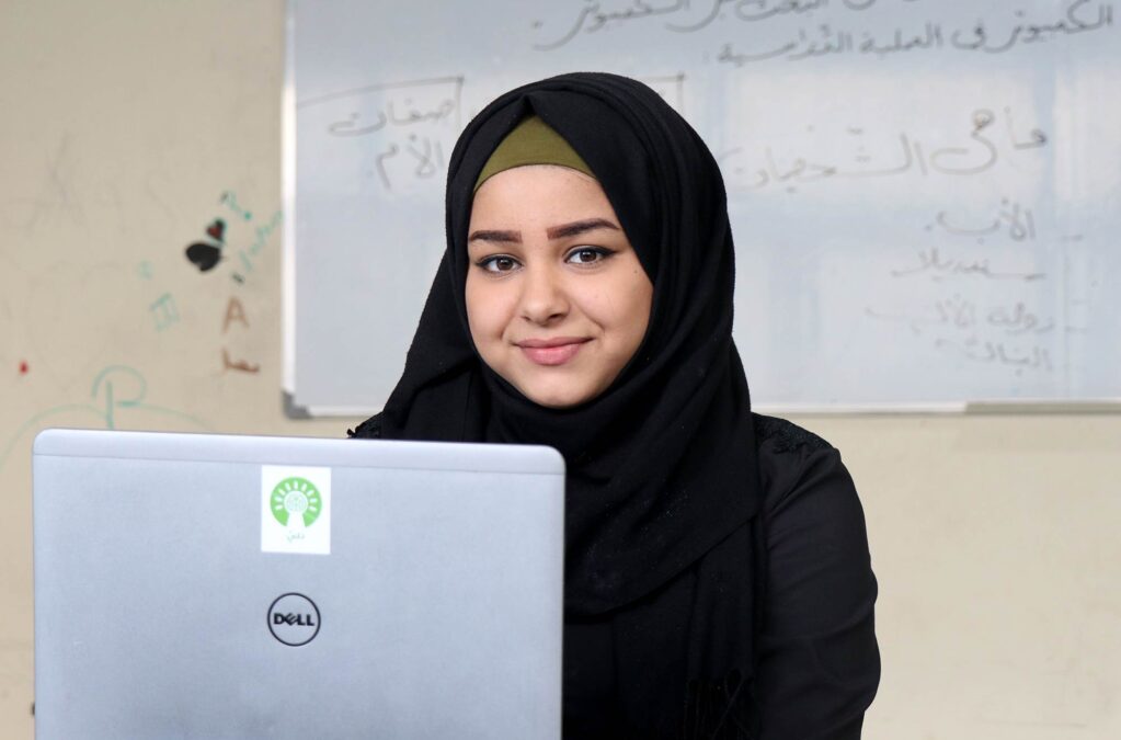 A young girl with a computer provided by Thaki